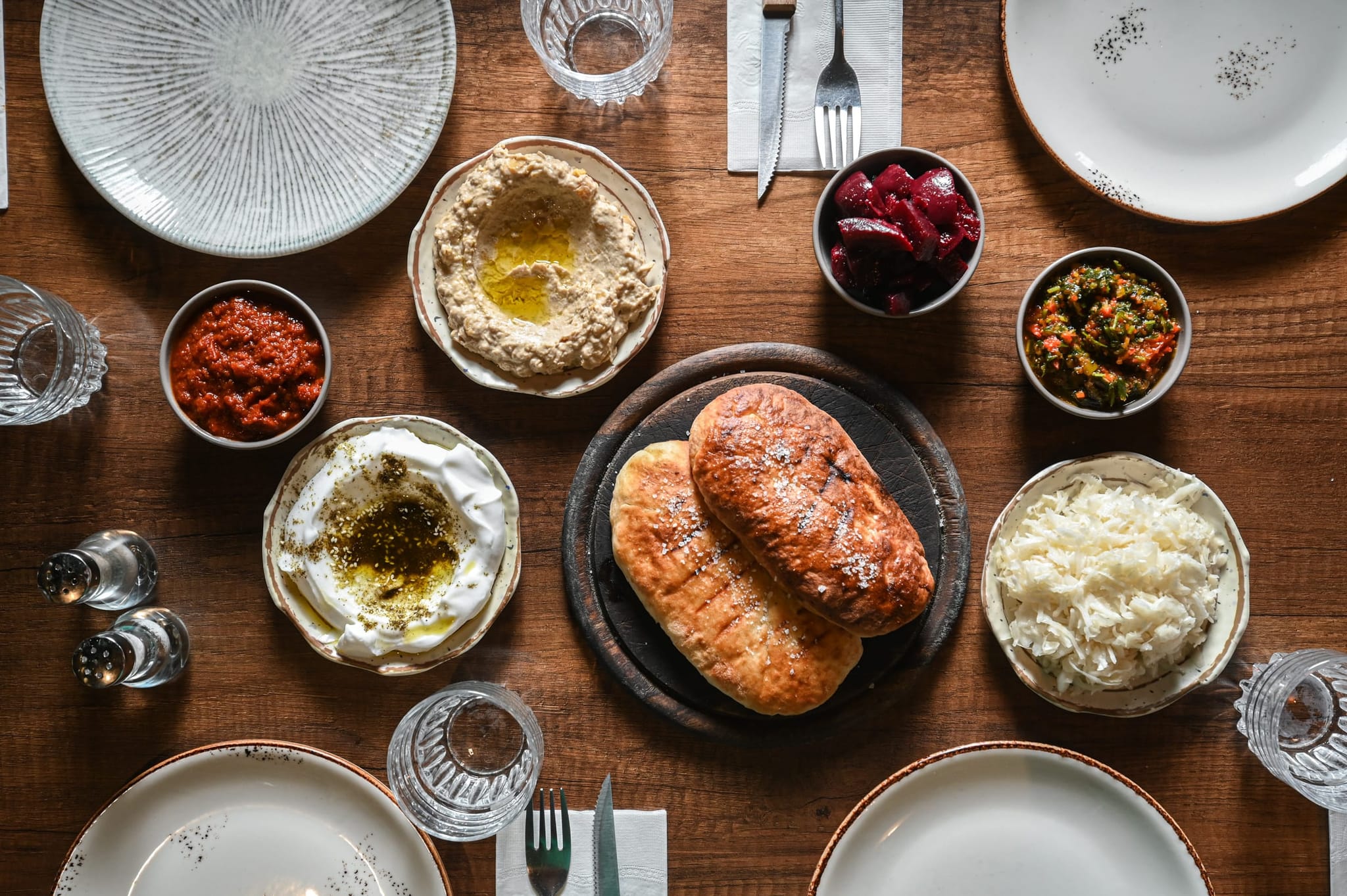 טאפס ראשונות: מגוון סלטים ומטבלים עם מאפה לחם הבית